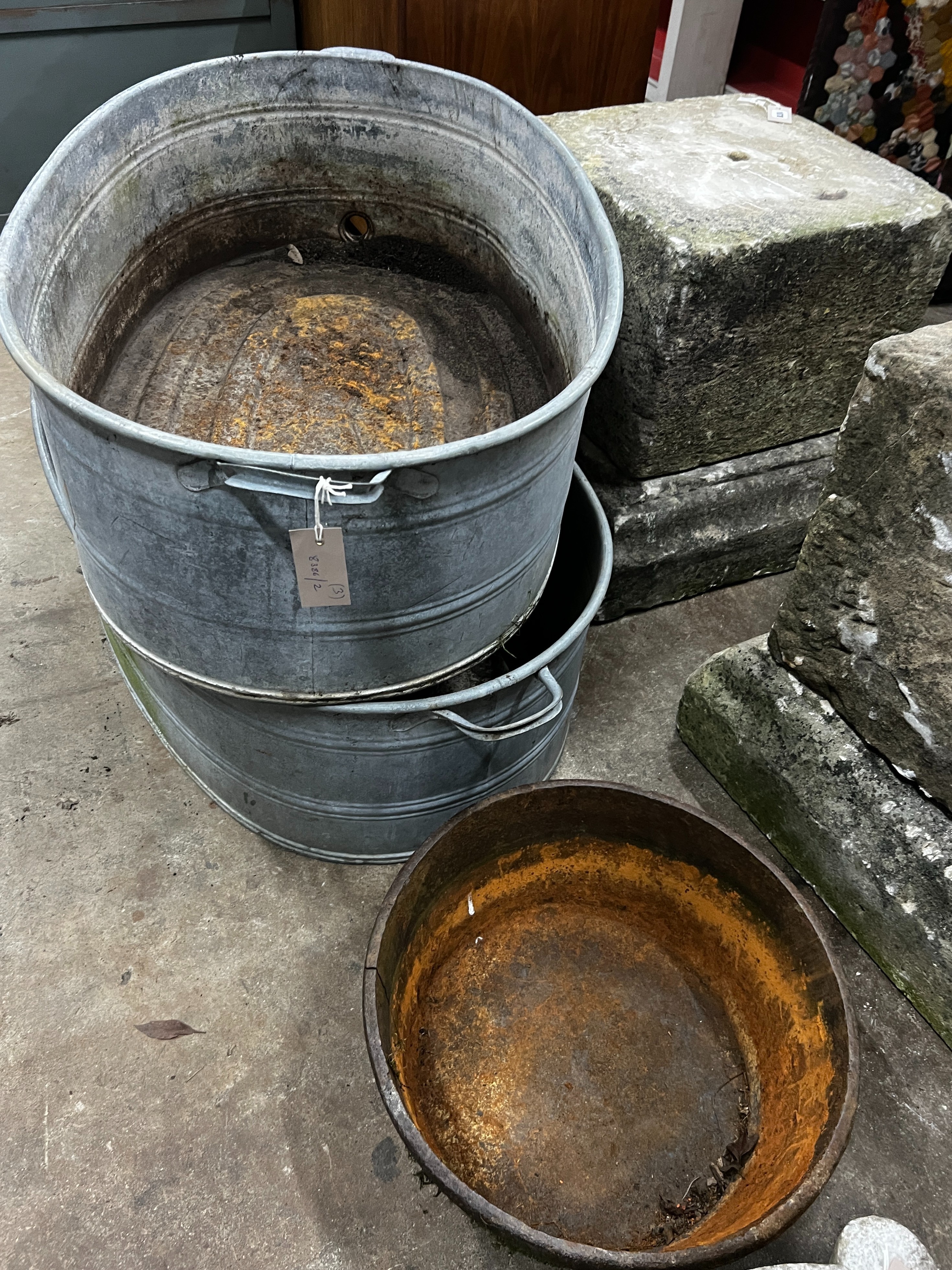 A pair of oval vintage galvanised zinc water troughs, length 104cm, depth 58cm, height 28cm together with a smaller circular cast iron planter